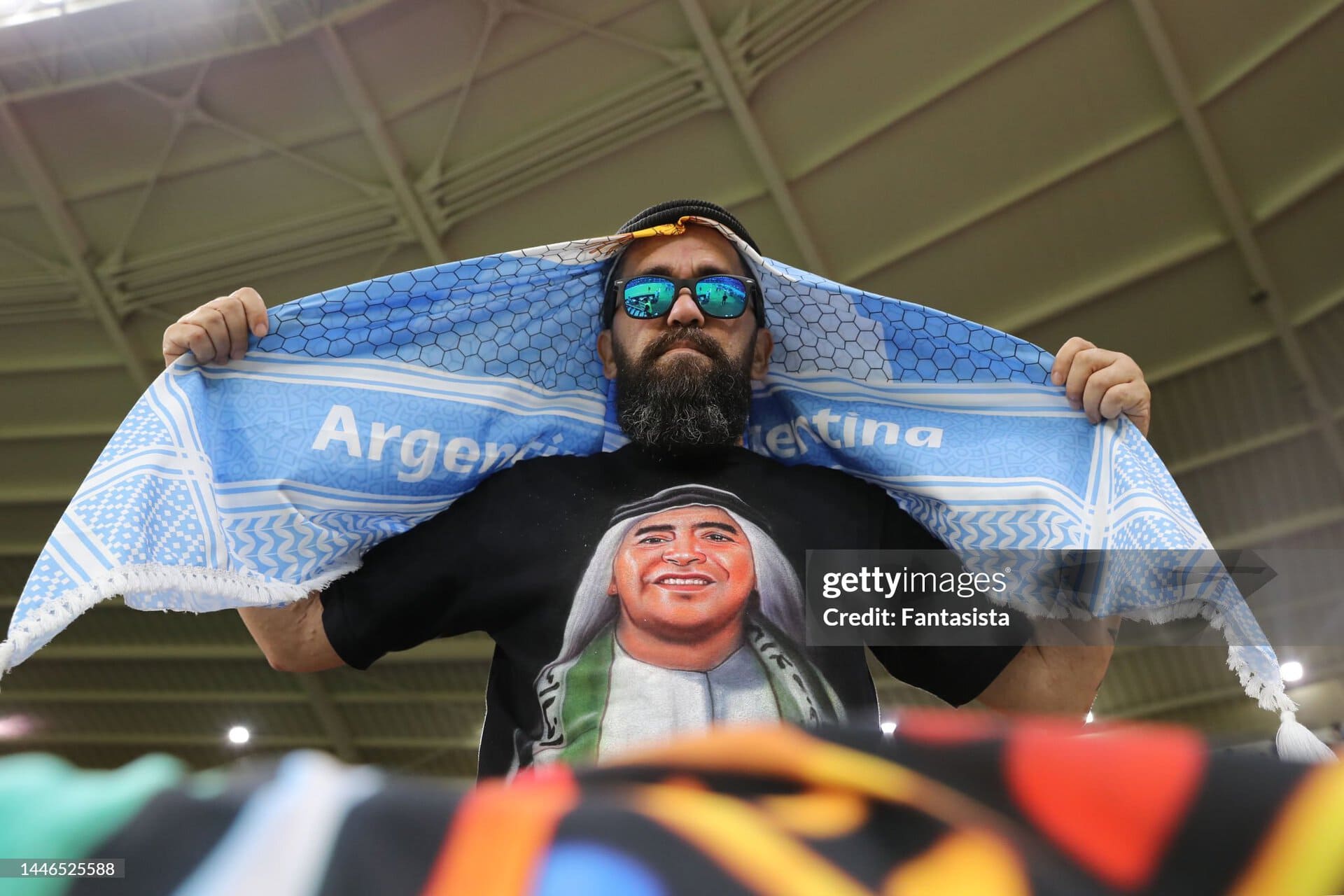 Hincha argentino con una remera de Diego Maradona usando estola palestina durante el Mundial de Qatar 2022.